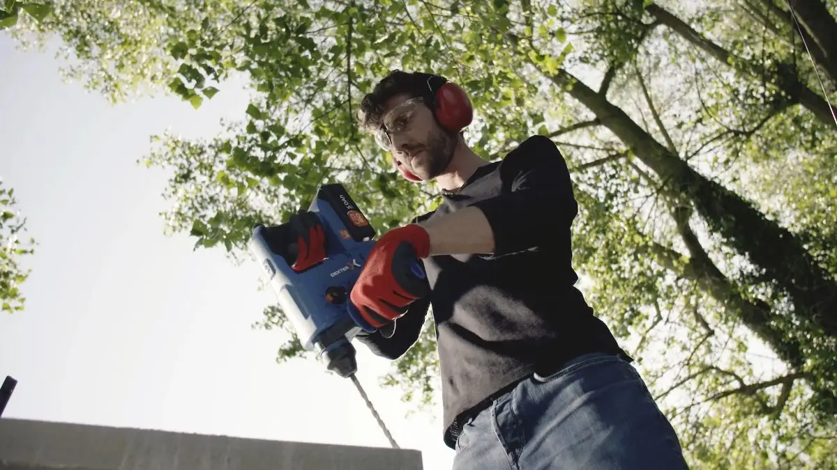 Publicité batterie universelle : perçage en contre-plongée dans le jardin
