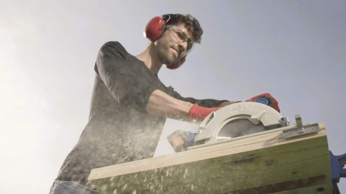Publicité batterie universelle : découpe d’une planche à la scie circulaire sans fil