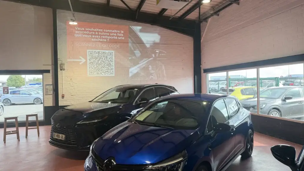 Écran de vidéoprojection et QR code - intégration audiovisuelle salle de vente aux enchères Mercier Automobiles